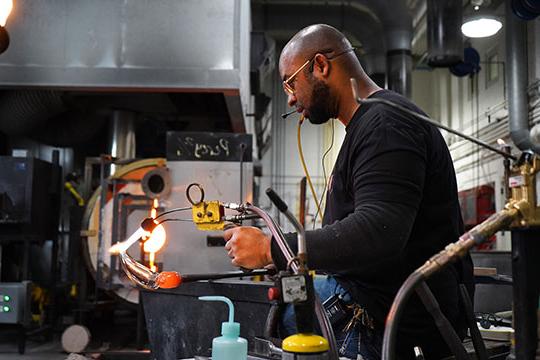 man making glass sculpture